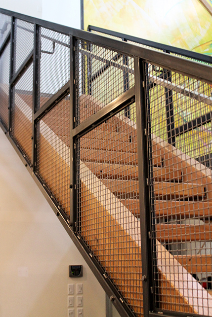 The staircase to the mezzanine made from natural wood with iron details